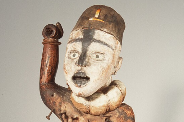 Afbeedling van een Nkisi nkondi- beeld uit de collectie van het Nationaal Museum van Wereldculturen. Een nkisi is een kracht of geest uit de onzichtbare wereld van de doden, die ook in een beeld kan huizen. De nganga - de rituele specialist - bezielt een nkisi door er krachtstof - bilongo - aan te bevestigen, hij brengt het beeld tot leven.