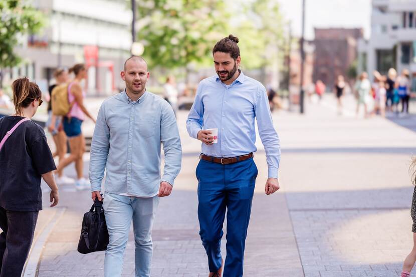 Twee medewerkers van de inspectie wandelend buiten op straat