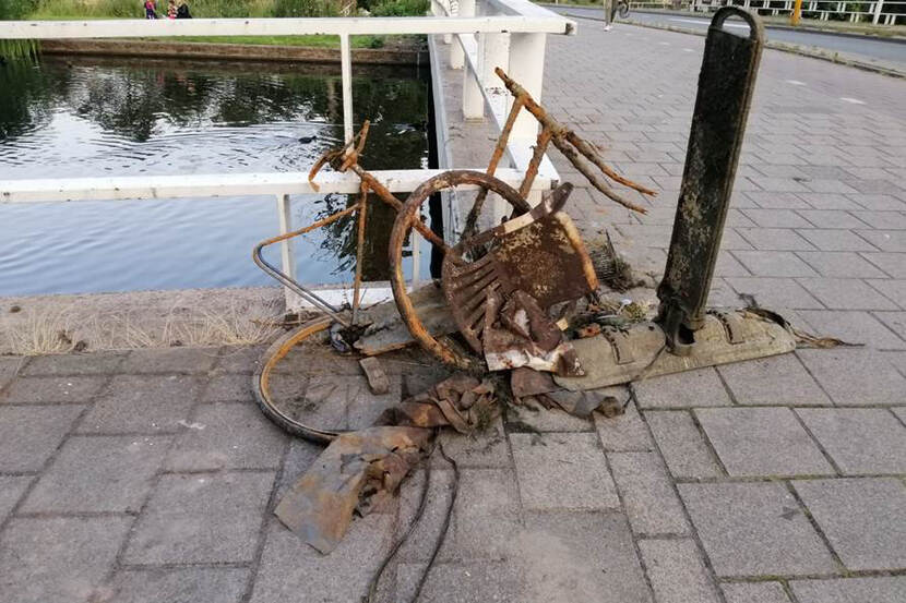 Afbeelding van geroeste voorwerpen zoals een fietsframe die door magneetvissen uit het water zijn gehaald.